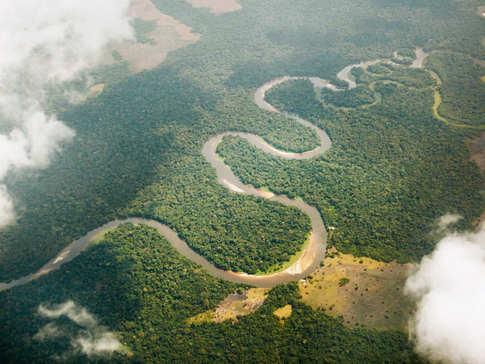Congo waterfall with bridge and green cliffs under cloudy sky